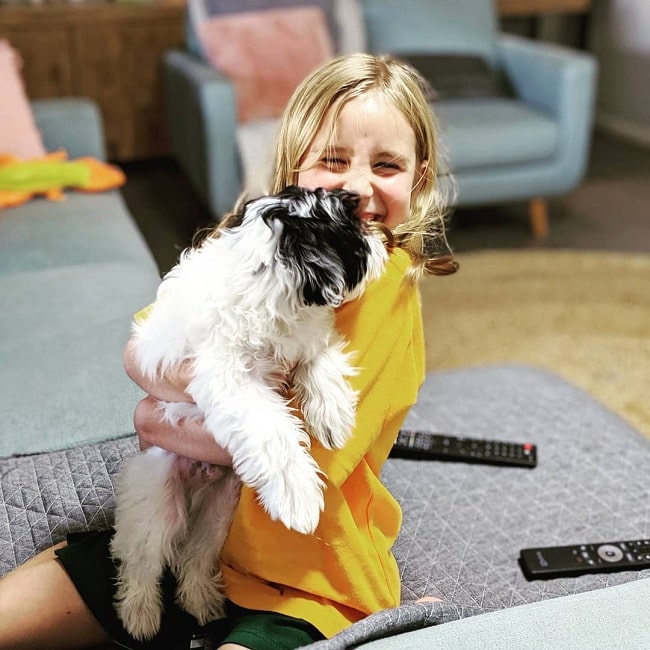 A girl looking happy with a Maltipoo